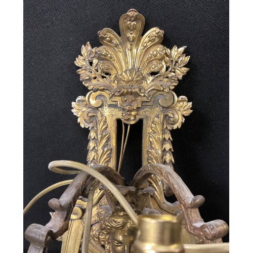 1023 - A pair of Baroque Renaissance style gilt metal wall lights, cast floral wall mounts with mask heads,... 