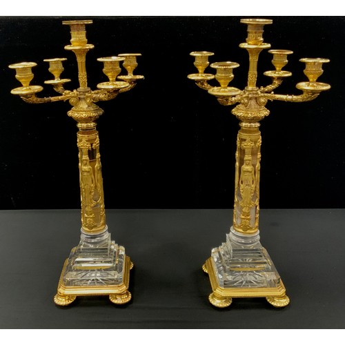 1024 - A pair of Egyptian Revival gilt metal and glass candelabra, each with central sconce surrounded by f... 