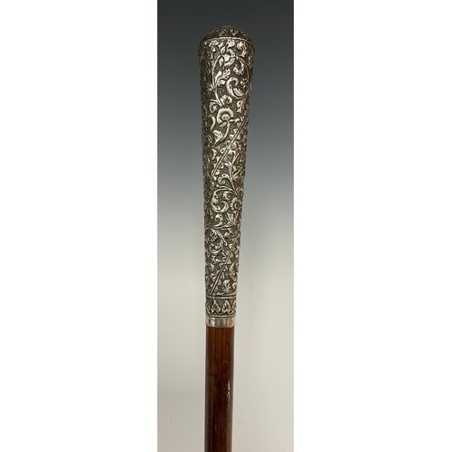 688 - An Indian silver handled walking stick, embossed floral scrolling handle, tapering shaft with bound ... 