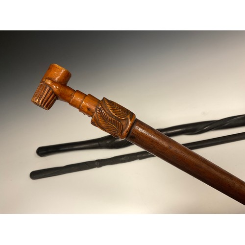 693 - An Irish folk art, carved bog oak walking stick, carved with spreading tendrils of clover to upper h... 