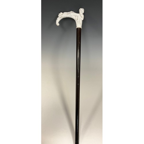 707 - A late 19th century walking cane, the white glazed porcelain handle / pommel, modelled as two scanti... 