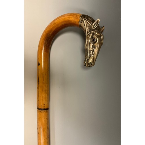 708 - A late 19th century bamboo walking stick, the handle terminal cast in silver metal as the head of a ... 