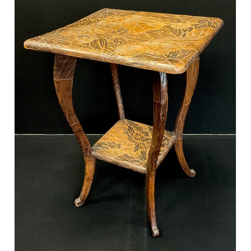 1057 - A Liberty carved hardwood two tier rounded square occasional table with floral and foliate decoratio... 