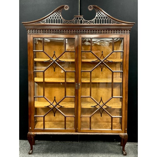 1050 - A large Chippendale Revival mahogany display cabinet, bold swan neck pediment pierced with Gothic tr... 