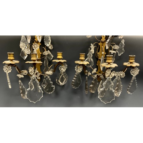 1022 - A pair of 19th century French gilt metal and cut glass three branch wall lights, circular candle sco... 