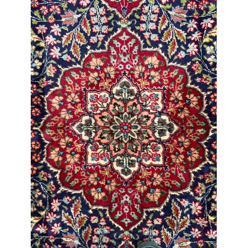 1283 - A Persian Tabriz carpet, all over floral garden design in red, blue, crean, green and pink on a red ... 