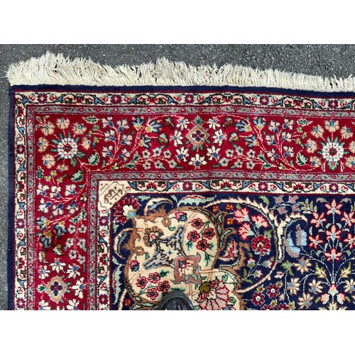 1283 - A Persian Tabriz carpet, all over floral garden design in red, blue, crean, green and pink on a red ... 