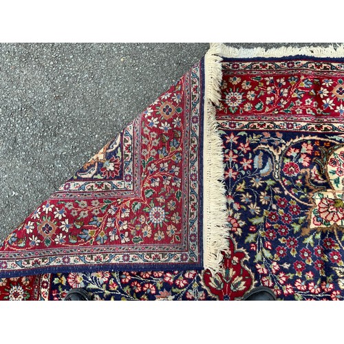 1283 - A Persian Tabriz carpet, all over floral garden design in red, blue, crean, green and pink on a red ... 