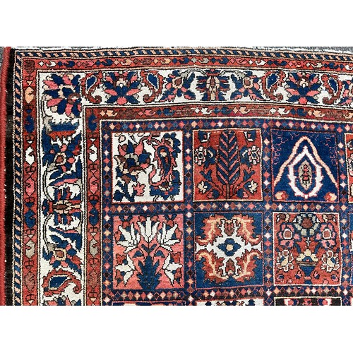 1284 - A Persian Baktiari hand-knotted carpet with central field of forty five floral and geometric panels,... 