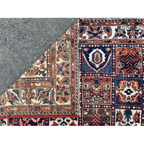 1284 - A Persian Baktiari hand-knotted carpet with central field of forty five floral and geometric panels,... 