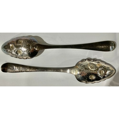 54 - A matched pair of George III silver berry spoons, the embossed bowls with traces of gilding, London ... 