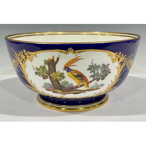 63 - A large Mintons pedestal bowl, printed and painted with reserves of fanciful birds, with raised gilt... 