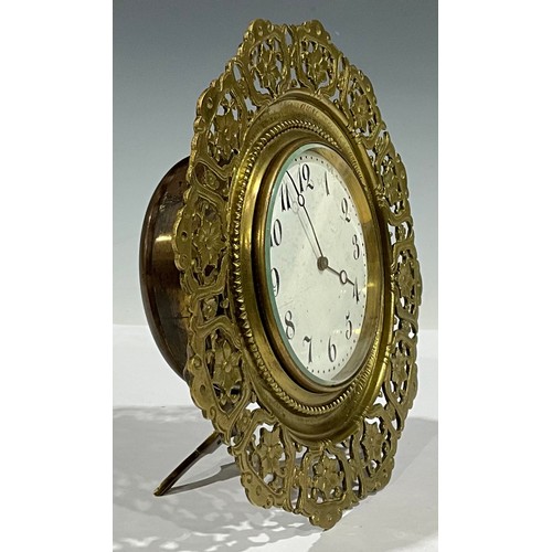 95 - A Victorian brass easel strutt timepiece, Arabic numerals on circular white dial, pierced floral fra... 