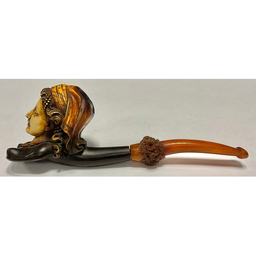 96 - A meeschaum pipe, the bowl as a lady wearing a head scarf, the amber stem carved with flowers, 20cm ... 