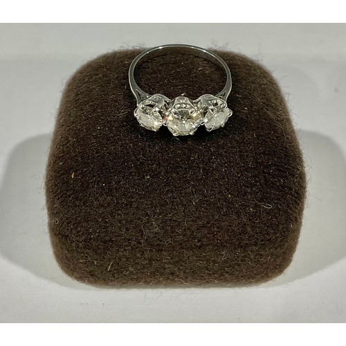 414 - An unmarked white gold three stone diamond ring, the central stone approx. 0.5ct, flanked by two fur... 