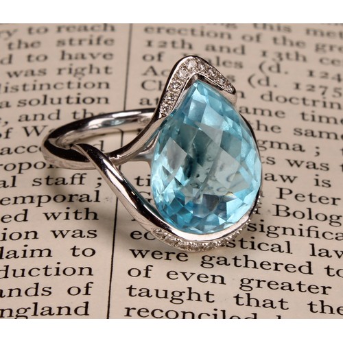 420 - An impressive topaz and 18ct white gold ring, the large sky blue pear shape facet cut stone set with... 