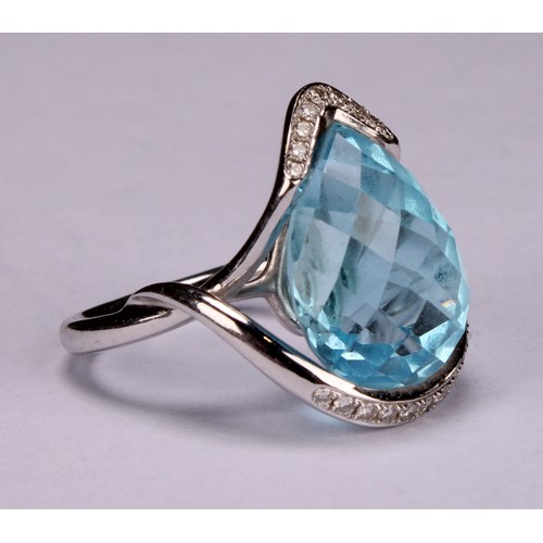 420 - An impressive topaz and 18ct white gold ring, the large sky blue pear shape facet cut stone set with... 