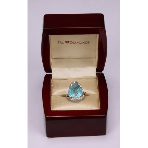 420 - An impressive topaz and 18ct white gold ring, the large sky blue pear shape facet cut stone set with... 