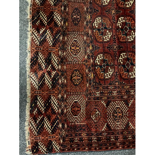 1289 - A Turkman Bokhara rug, hand-knotted, typical repeating geometric design, in red with black, orange, ... 