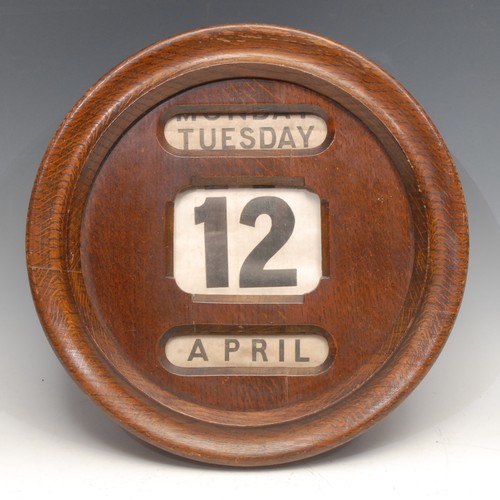 3302 - An early 20th century oak circular wall mounted perpetual calendar, glazed apertures for day, date a... 