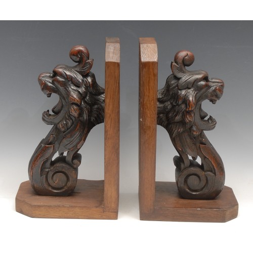 3167 - A pair of substantial oak country house bookends, the scrolling brackets boldly carved with lion mas... 