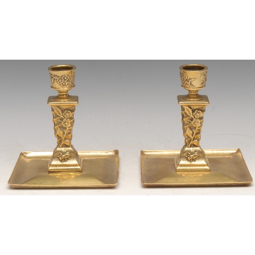 3149 - A pair of Arts & Crafts period brass chambersticks, in the Aesthetic Movement taste with insects and... 