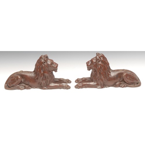3168 - A pair of Victorian cast iron models, of lions, after Sir Edwin Landseer, painted in iron red, 30.5c... 