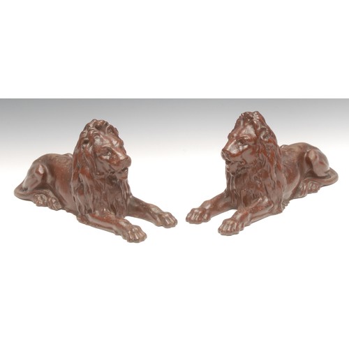 3168 - A pair of Victorian cast iron models, of lions, after Sir Edwin Landseer, painted in iron red, 30.5c... 