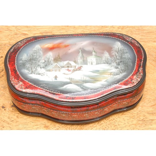 3179 - A reproduction Russian black lacquer box, of serpentine form, the hinged cover painted with a frozen... 