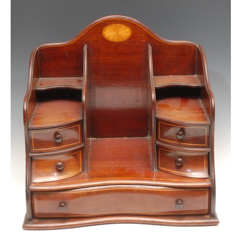 3322 - An Edwardian mahogany desk top companion, shaped cresting rail above an arrangement of pigeon holes ... 