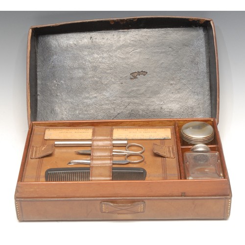 3293 - An early 20th century leather gentleman's dressing case, hinged cover enclosing an arrangement of ac... 