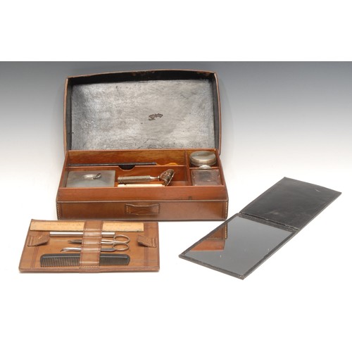 3293 - An early 20th century leather gentleman's dressing case, hinged cover enclosing an arrangement of ac... 