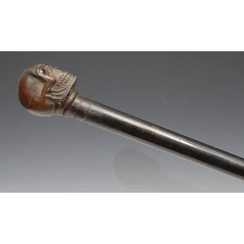 3711 - The Macabre - a bronze mounted novelty walking stick, the pommel as a skull, glass eyes, ebonised ca... 