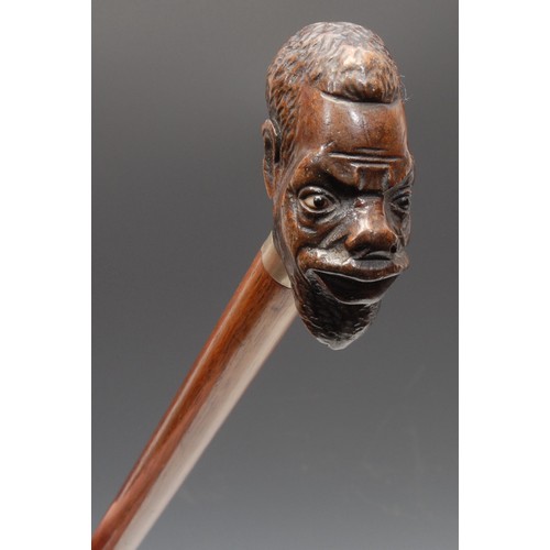 3709 - An early 20th century novelty walking stick, the pommel carved as the head of a man of African desce... 