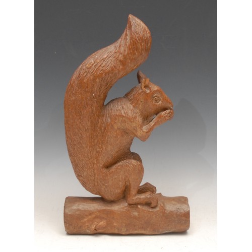 3301 - An early 20th century oak carving, of a squirrel eating an acorn, 33cm high