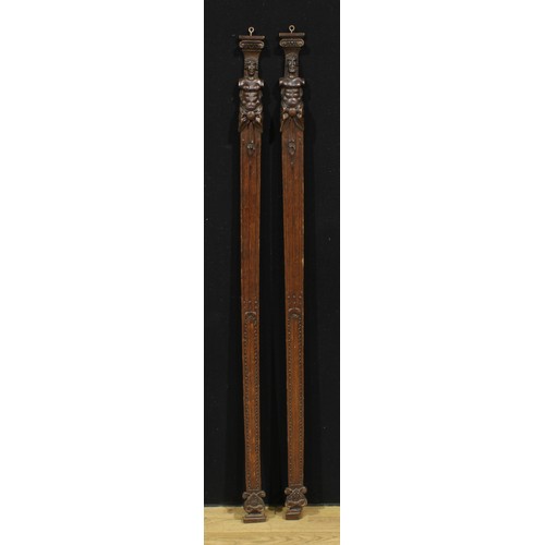 3692 - A pair of slender Arts and Crafts carved oak pilasters, each carved with a male bust, 136cm long, 7c... 