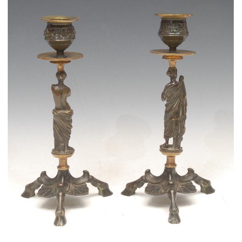 3139 - A pair of 19th century Grand Tour parcel-gilt and brown patinated bronze sculptural tripod candlesti... 