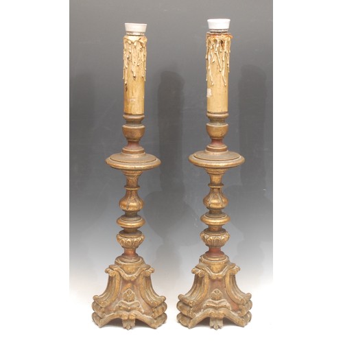 3129 - A pair of 18th/19th century giltwood Portuguese candlesticks, turned and gadrooned columns, C-scroll... 