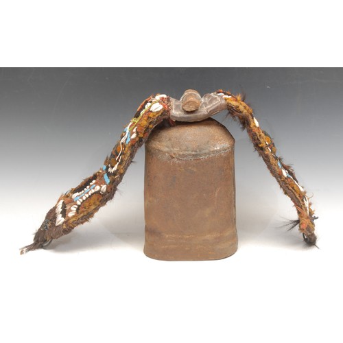 3314 - An early 20th century Turkish wrought iron camel bell, later floral pattern woolwork and cowrie shel... 