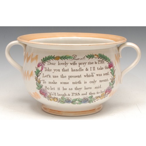 3328 - An English lustre pottery marriage chamber pot, printed with verse, the interior with caricature and... 