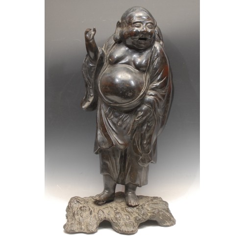 3097 - A large Japanese bronze figure of a standing Budai, laughing and bearing a cloth sack, cast base, 64... 