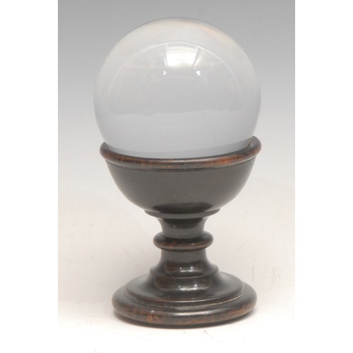 3462 - Mysticism & The Occult - a small crystal ball, turned ebonised stand, 11cm high overall