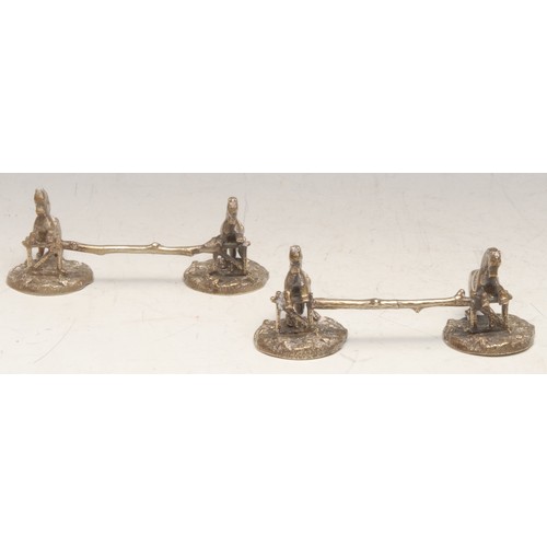 3134 - A pair of 19th century electrotype knife rests, each modelled as horses leaping over a gate, on natu... 
