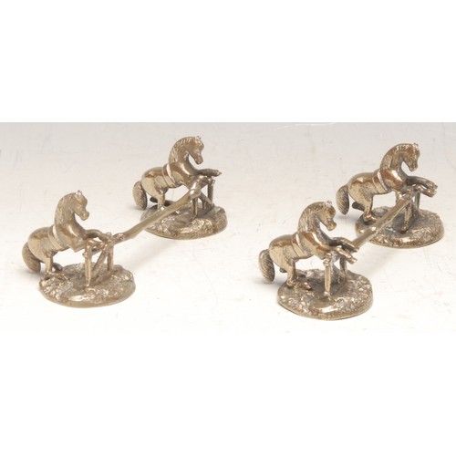 3134 - A pair of 19th century electrotype knife rests, each modelled as horses leaping over a gate, on natu... 