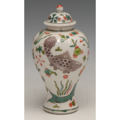 3038 - A Chinese ovoid vase and cover, decorated in the famille wucai palette with fish, flowers and scatte... 