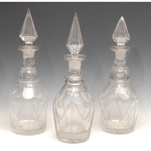 3123 - A near set of three 19th century mallet shaped decanters, pointed stoppers, star-cut bases, the tall... 