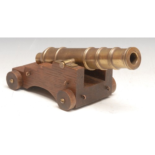 3537 - A 19th century bronze model, of a cannon, on a later wooden base, 11cm high, 22cm long overall