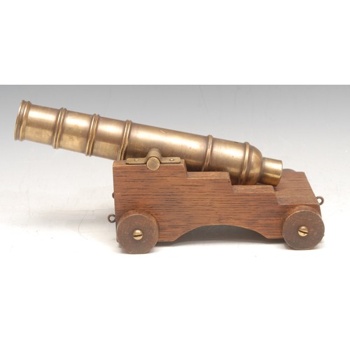 3537 - A 19th century bronze model, of a cannon, on a later wooden base, 11cm high, 22cm long overall