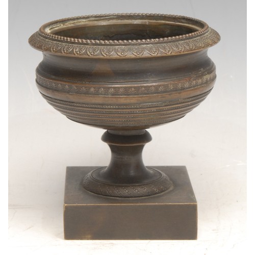 3083 - A Grand Tour design bronze miniature pedestal urn, the beaded rim above a band of palmettes, square ... 