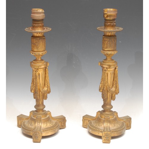 3163 - A pair of Louis XVI Revival ormolu candlesticks, later fitted as table lamps, the collars cast with ... 